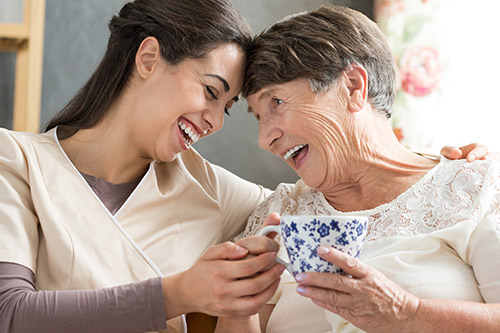 Image of a staff member and a resident enjoying a cup of tea.